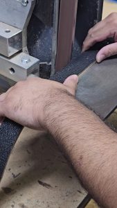 Using a belt grinder  as the perfect leatherworking tool to sand the edges of a belt